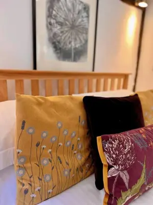 a bed with two pillows on top of it at Hideaway Cottage in Ludlow