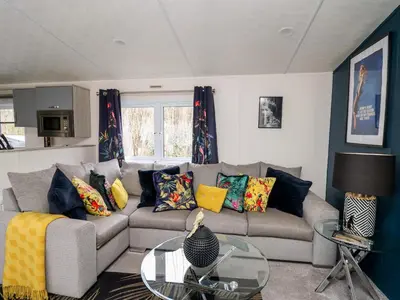 a living room with a gray couch with colorful pillows at The Hideout in Llanina