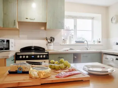 a kitchen with a cutting board with grapes and cheese at 2 Bed in Brecon oc-51153 in Llandefalle