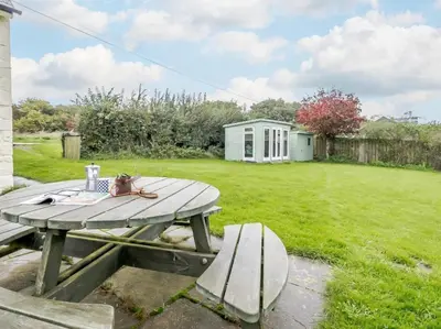 a picnic table and a bench in a yard at 2 Bed in Brecon oc-51153 in Llandefalle