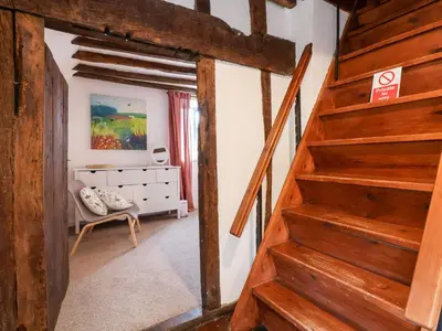 a hallway with a wooden staircase in a house at The Brewhouse in Church Stretton