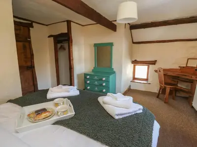 a bedroom with two beds with towels and a table at Y Cartws in Llanybydder