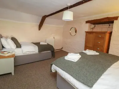 a small bedroom with two beds and a dresser at Y Cartws in Llanybydder