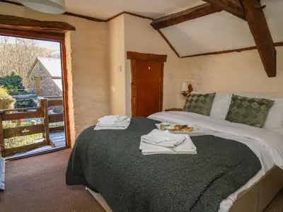 a bedroom with a bed with towels on it at Y Cartws in Llanybydder