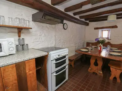 a kitchen with a white stove and a table at Y Cartws in Llanybydder