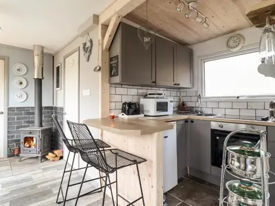 a kitchen with a counter and chairs and a stove at Chalet Forte in Aberdyfi
