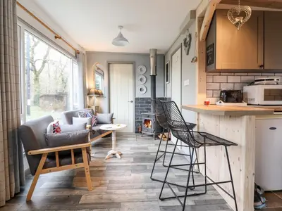 a kitchen and living room with a couch and chairs at Chalet Forte in Aberdyfi