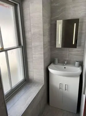 a bathroom with a white sink and a mirror at Maisonette flat Aberystwyth in Aberystwyth