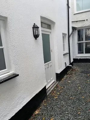a white building with a door and a street light at Maisonette flat Aberystwyth in Aberystwyth