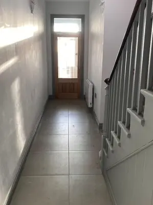 a hallway with a door and a stairway with a hallwayngthngthngthngth at Maisonette flat Aberystwyth in Aberystwyth