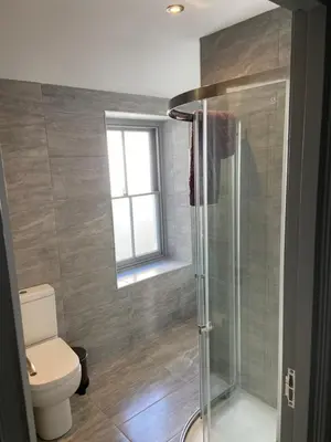 a bathroom with a toilet and a glass shower at Maisonette flat Aberystwyth in Aberystwyth