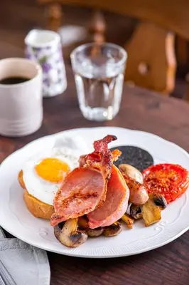 a plate of breakfast food with an egg and bacon at The Cedars in Builth Wells