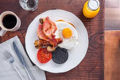 a plate of breakfast food on a wooden table at The Cedars in Builth Wells
