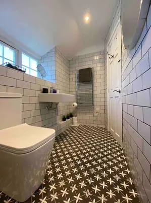 a bathroom with a toilet and a black and white tile floor at Cosy Cottage in Aberaeron