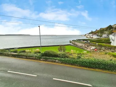 an empty road next to a body of water at 2 Bed in Aberdovey DY037 in Aberdyfi