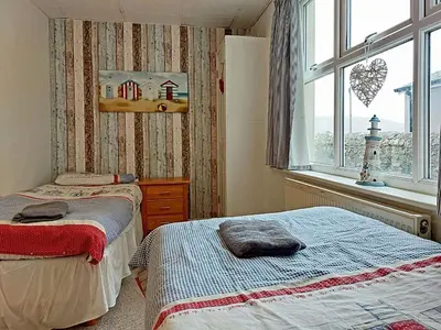 a bedroom with two beds and a window at Beach Front Apartment in Tywyn in Tywyn
