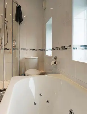 a white bath tub in a bathroom with a toilet at Beach Front Apartment in Tywyn in Tywyn
