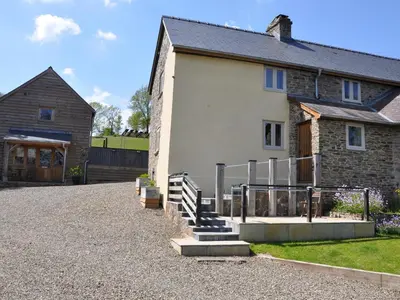 a house with a gravel driveway in front of it at Rockhill Farmhouse in Craven Arms
