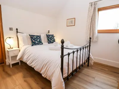 a bedroom with a black and white bed and a window at Rockhill Farm Hay Barn in Craven Arms