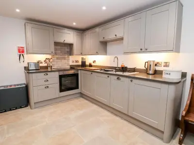 a white kitchen with white cabinets and appliances at Rockhill Farm Hay Barn in Craven Arms