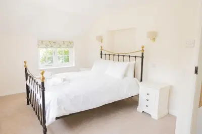 a bedroom with a large bed and a white nightstand at Afonfa - Llanuwchllyn in Bala