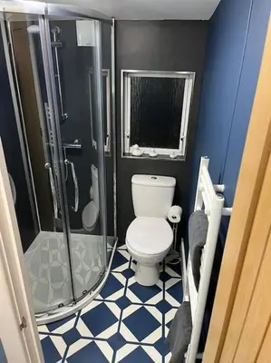 a small bathroom with a toilet and a shower at The Cherries - Caer beris holiday park 2 bedroom lodge - No commercial vehicles allowed on site in Builth Wells