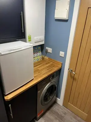 a laundry room with a washer and dryer next to a door at The Cherries - Caer beris holiday park 2 bedroom lodge - No commercial vehicles allowed on site in Builth Wells