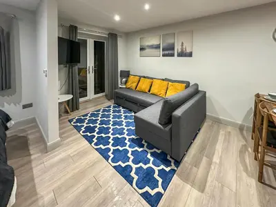 a living room with a couch and a blue rug at The Annexe in Guilsfield