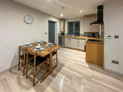 a kitchen with a table and a clock on the wall at The Annexe in Guilsfield