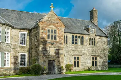 an old stone house with a cross on top at Gors-Y-Gedol in Dyffryn