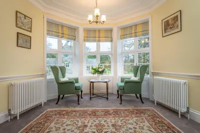 a living room with chairs and a table and windows at Gors-Y-Gedol in Dyffryn