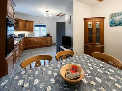 a kitchen with a table with chairs and a dining room at Glanllyn Lodge in Llanuwchllyn