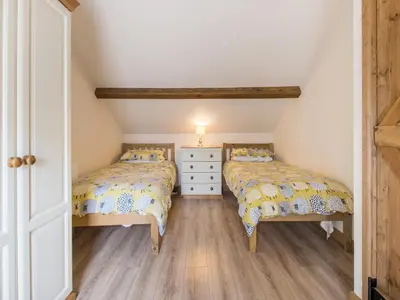two twin beds in a room with a attic at Frondeg Bach in Cross Inn
