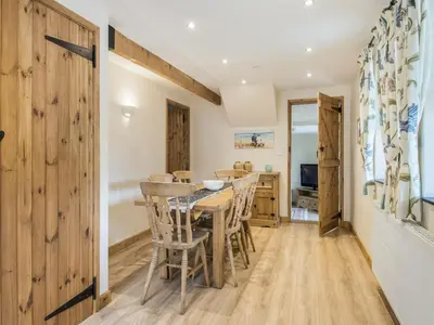 a kitchen and dining room with a table and chairs at Frondeg Bach in Cross Inn
