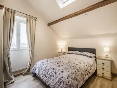 a bedroom with a bed and a window at Frondeg Bach in Cross Inn