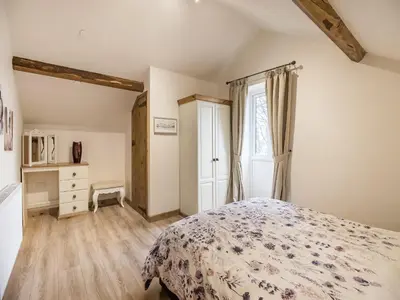 a bedroom with a bed and a window at Frondeg Bach in Cross Inn