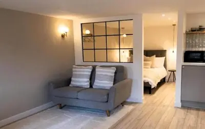 a living room with a chair and a bed at The Cwtch in Ludlow