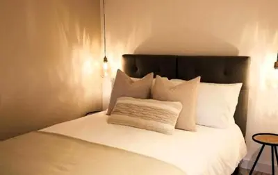 a white bed with white pillows and a black headboard at The Cwtch in Ludlow