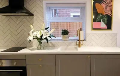 a kitchen with a sink and a vase of flowers at The Cwtch in Ludlow