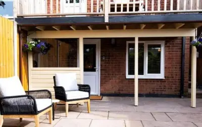 a patio with two chairs and a building at The Cwtch in Ludlow
