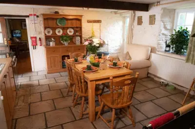 a kitchen with a table and chairs in a room at Yr Hen Efail - Old Smithy in Tregaron