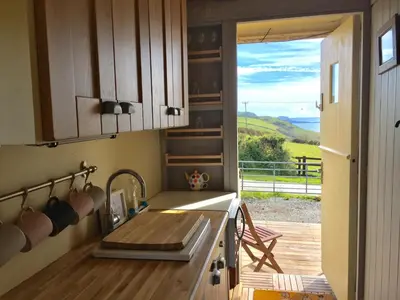 a kitchen with a sink and a view of a deck at Sea the Stars in New Quay