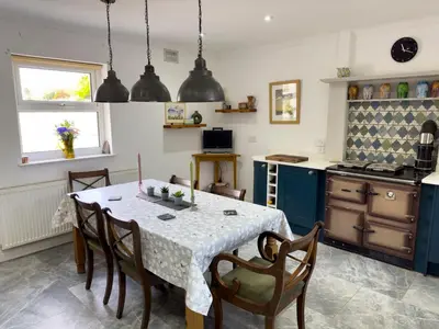 a kitchen with a table and chairs in a kitchen at Crogal Farmhouse in New Quay