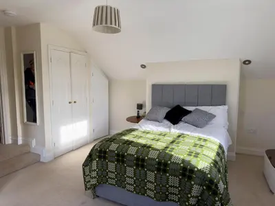 a bedroom with a bed with a green and white blanket at Crogal Farmhouse in New Quay