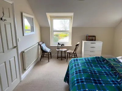 a bedroom with a bed and a table and chairs at Crogal Farmhouse in New Quay