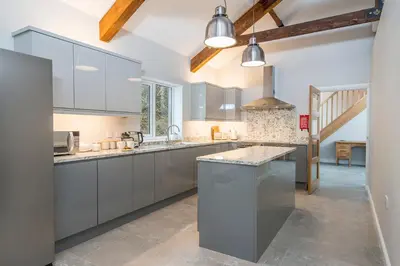 a kitchen with gray cabinets and a large island at Llwynblyfyn in Llandeilo