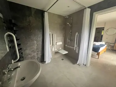 a bathroom with a sink and a shower and a bed at Llwynblyfyn in Llandeilo