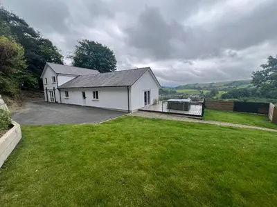 a large white house with a large yard at Llwynblyfyn in Llandeilo