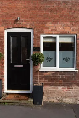 a black door and two windows on a brick building at The Hive, Central Ludlow, Free Parking, Boutique Hotel Style in Ludlow
