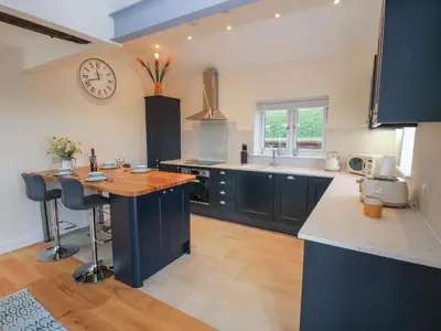 a kitchen with a table and a clock on the wall at Border View Lodge in Welshpool